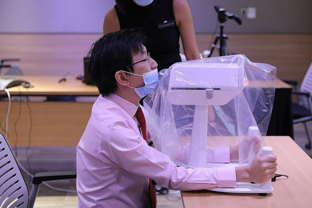  ​Dr
Luke Tay, a consultant at SGH who was part of the team that developed the
robot, demonstrating how a patient would position himself when undergoing a
swab test done by the SwabBot.ST
PHOTO ONG WEE JIN